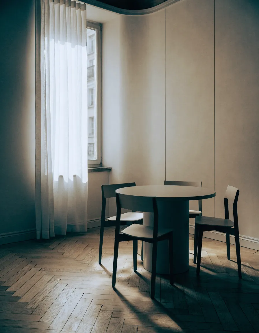 Vue intérieure d'un bureau en lumière naturelle, table de travail nue et cloison vitrée.